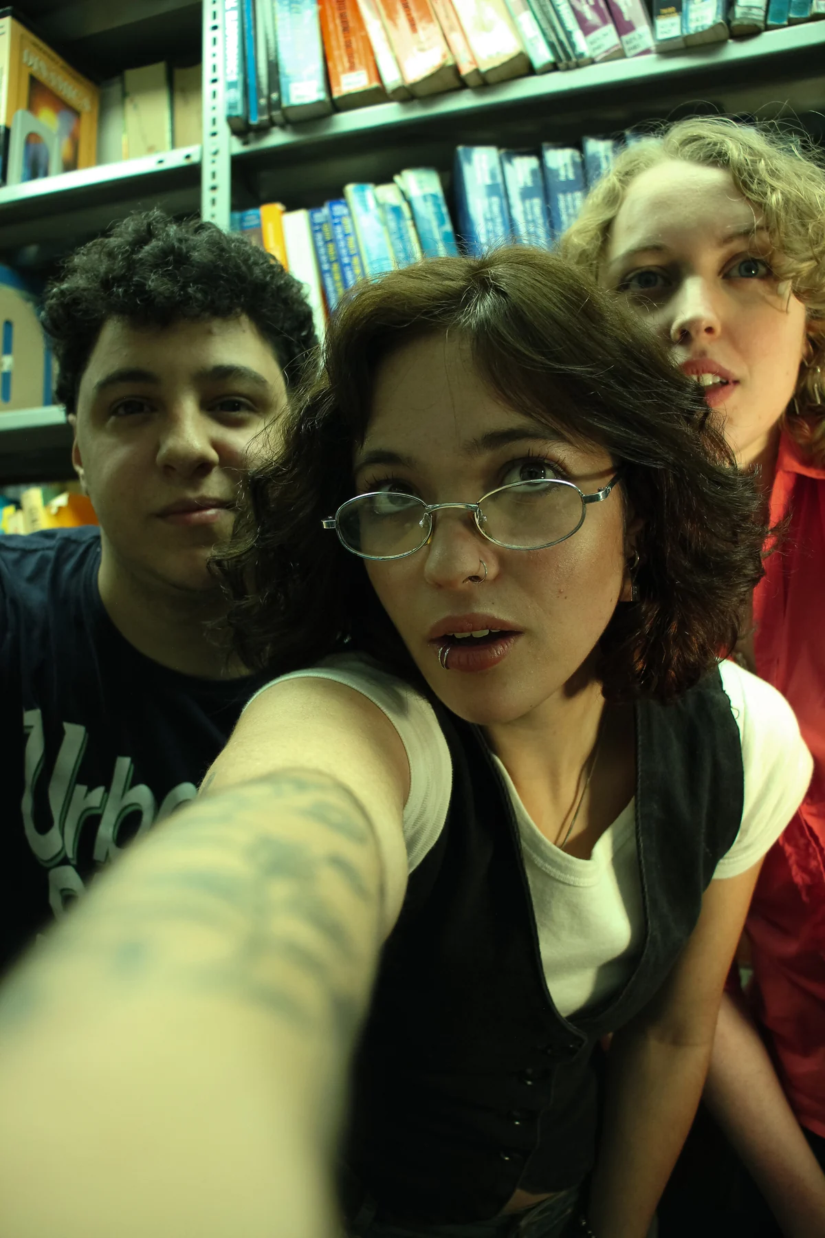 Selfie de Agus, Ju y Vic en una biblioteca.